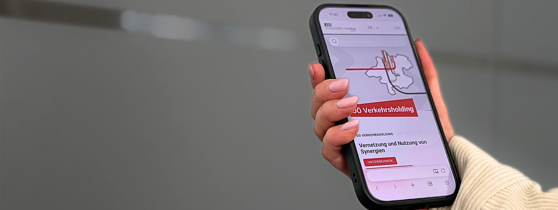 Smartphone displays a website for a transport holding company and the networking of synergies.